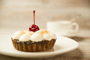 Kek kiraz ve masada bir fincan