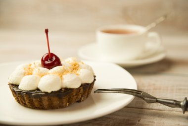 Kek kiraz ve masada bir fincan