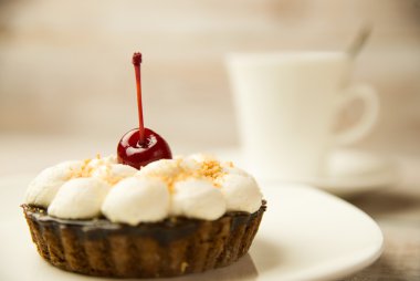 Kek kiraz ve masada bir fincan