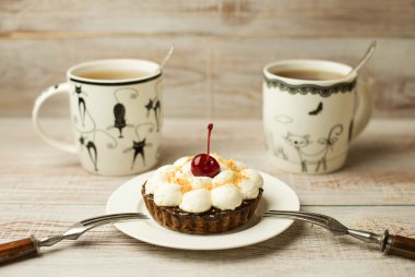 Kek kiraz ve masada bir fincan