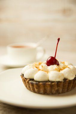 Kek kiraz ve masada bir fincan