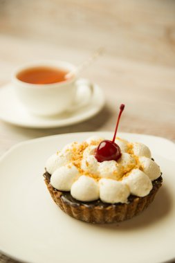 Kek kiraz ve masada bir fincan