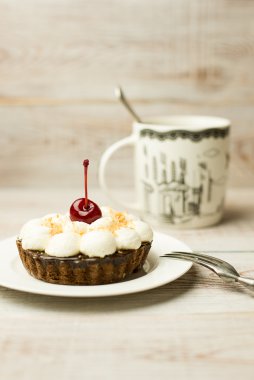 Kek kiraz ve masada bir fincan