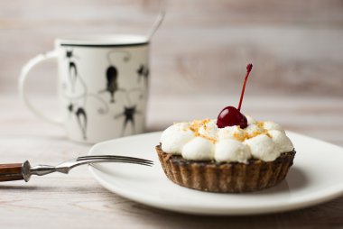 Kek kiraz ve masada bir fincan