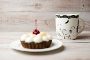 Kek kiraz ve masada bir fincan