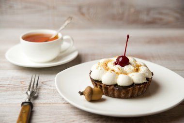 Kek kiraz ve masada bir fincan