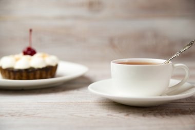 Kek kiraz ve masada bir fincan