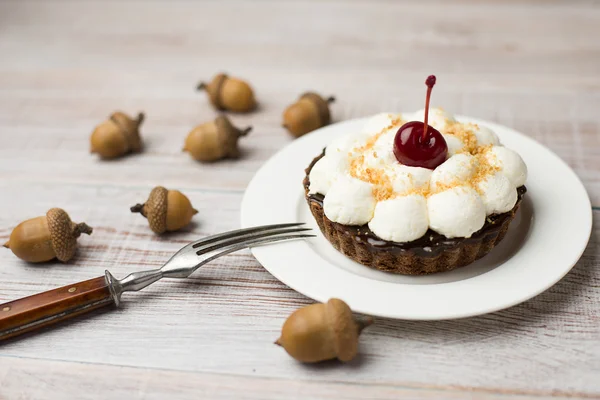 Cake with cherries and acorns on the table — Stock Photo, Image