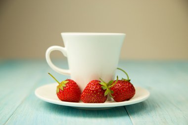 Bir bardak içki ve mavi üzerinde çilek ile