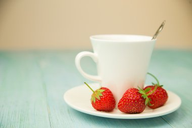 Bir bardak içki ve mavi üzerinde çilek ile