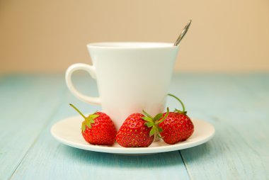 Bir bardak içki ve mavi üzerinde çilek ile