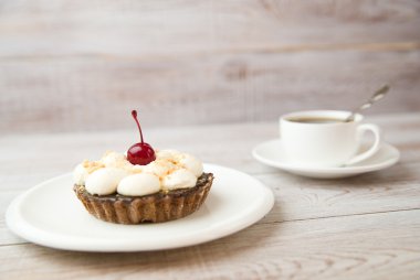 Kek kiraz ve masada bir fincan