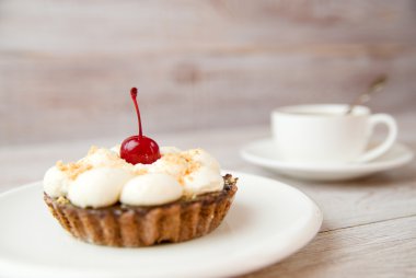 Kek kiraz ve masada bir fincan