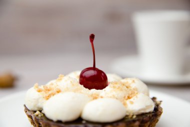 Kek kiraz ve masada bir fincan