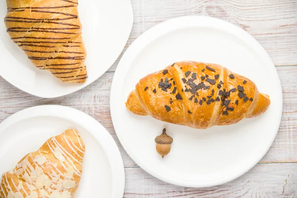 Algunos croissants en un plato blanco en la mesa —  Fotos de Stock