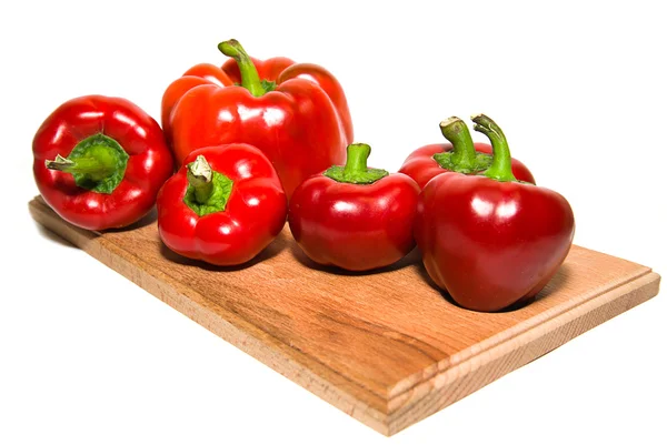 Several  peppers on a wooden cutting board. — Stock Photo, Image