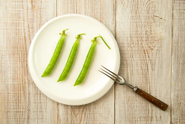 Vainas de guisantes verdes en el plato blanco . —  Fotos de Stock