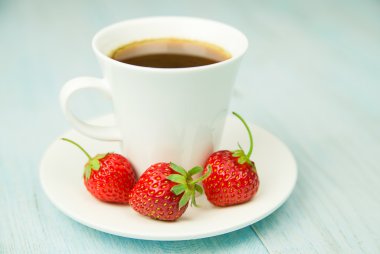 Bir bardak içki ve mavi üzerinde çilek ile