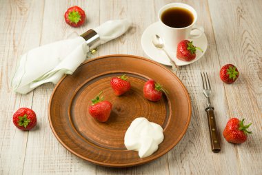 Olgun çilek meyve kahverengi bir plaka üzerinde