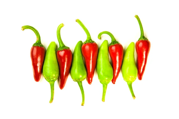 Muitos pimentos de pimenta vermelha e verde maduros em branco — Fotografia de Stock