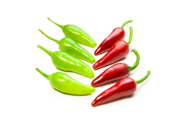 Viele reife rote und grüne Chilischoten auf weiß — Stockfoto