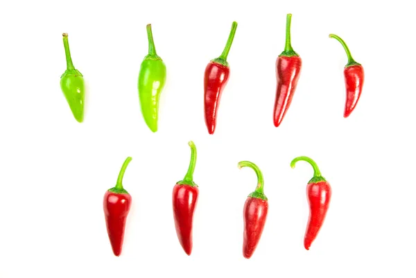Muitos pimentos de pimenta vermelha e verde maduros em branco — Fotografia de Stock