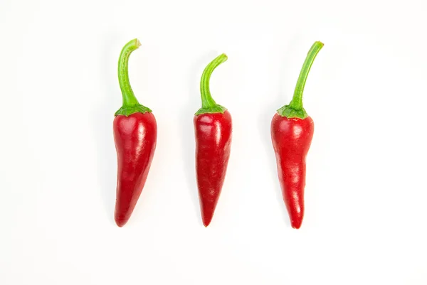 Três pimentas vermelhas maduras Chilli em branco — Fotografia de Stock