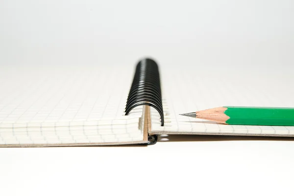 Caderno aberto e lápis sobre branco — Fotografia de Stock