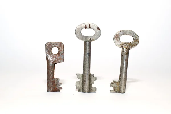 Tres llaves viejas sobre un fondo blanco —  Fotos de Stock