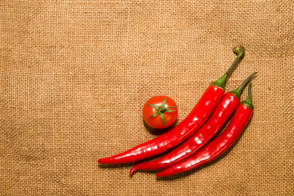 3 papryki chilli i wiśnia tomat na bardzo stary szmatką — Zdjęcie stockowe