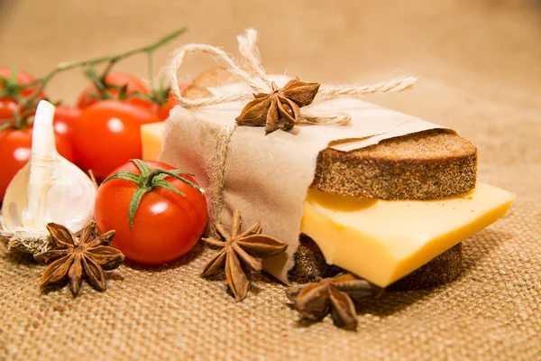 Sandwich with cheese wrapped in paper, cherry tomatoes and garli