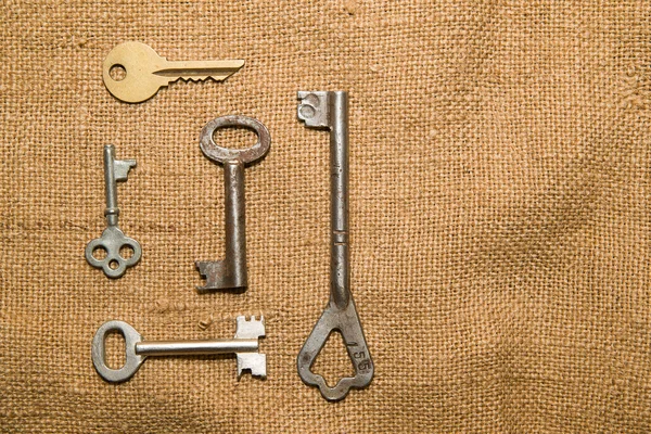 Пять старых ключей от сейфа на очень старой ткани — стоковое фото