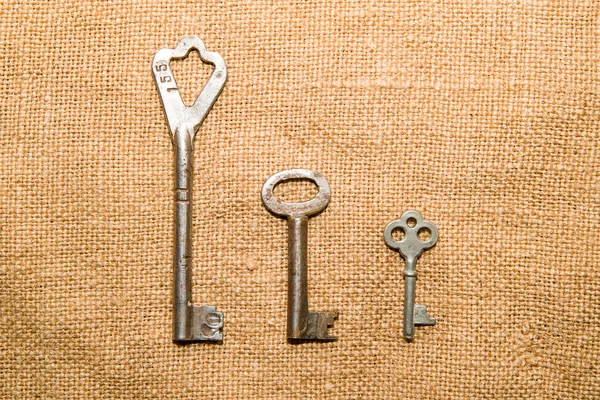 Three  old keys to the safe on a very old cloth — Stock Photo, Image