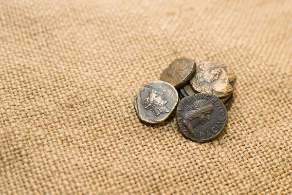 Antique  coins with portraits of emperors  on old cloth — Stock Photo, Image