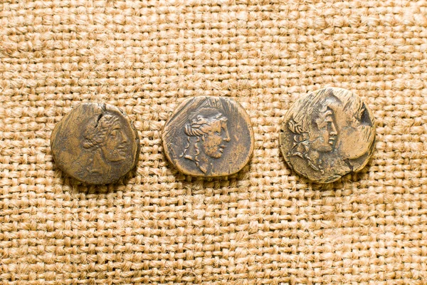 Antique  coins with portraits of emperors  on old cloth — Stock Photo, Image