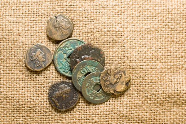 Antique  coins with portraits of emperors  on old cloth — Stock Photo, Image