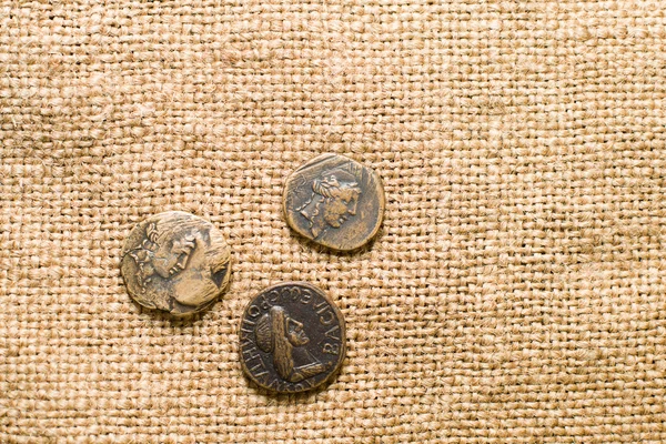 Antique  coins with portraits of emperors  on old cloth — Stock Photo, Image