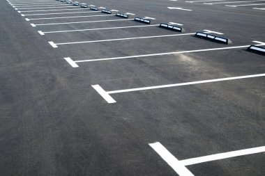 Markings on asphalt pavement indicating parking spaces clipart