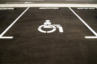 Markings on asphalt indicating a parking space for people with l clipart