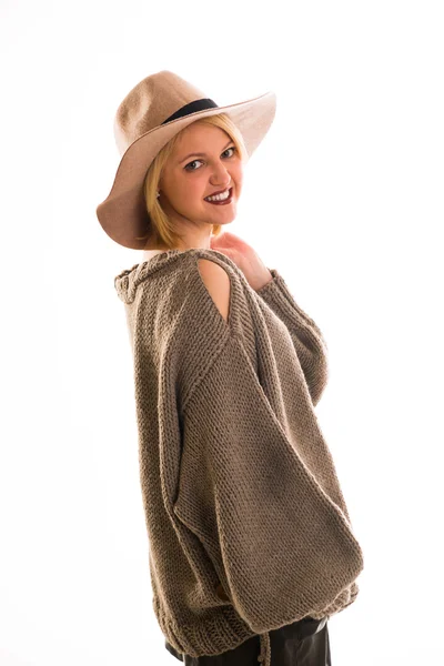 Woman in a sweater and cowboy hat smiling on a white background — Stock Photo, Image