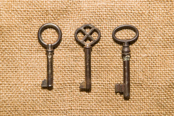 Kasanın bir çok eski kumaş üzerine üç eski anahtar — Stok fotoğraf