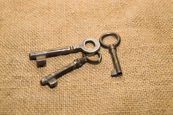 Kasanın bir çok eski kumaş üzerine üç eski anahtar — Stok fotoğraf
