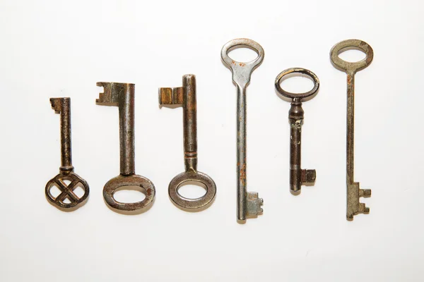 Six old keys to the safe on a white background — Stock Photo, Image