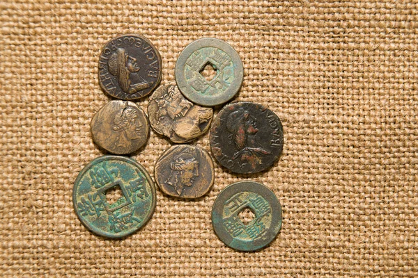 Antique  coins with portraits of emperors   on old cloth — Stock Photo, Image