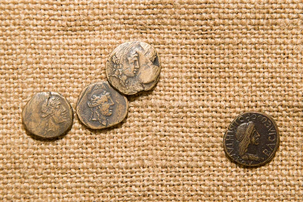 Antique  coins with portraits of emperors   on old cloth — Stock Photo, Image