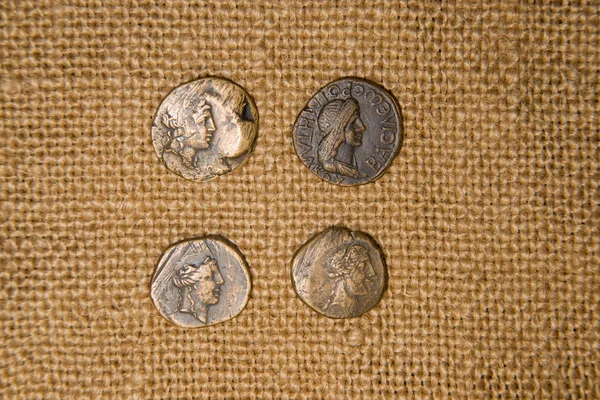 Antique  coins with portraits of emperors  on old cloth — Stock Photo, Image