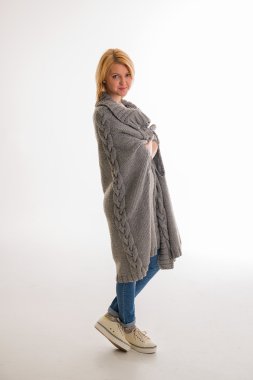 Beyaz bir arka plan üzerinde gülümseyen bir kazaklı kadın