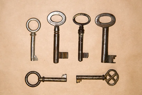 Tante chiavi vintage dalle serrature su carta artigianale — Foto Stock