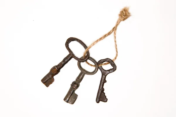 Beaucoup de clés vintage sur une corde sur un fond blanc — Photo