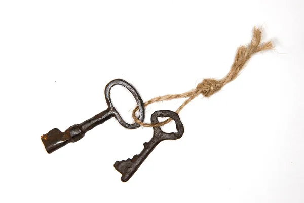 A lot vintage keys on a rope on a white background — Stock Photo, Image